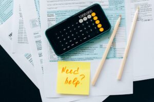 calculator, tax forms, and pencils.. need help? on a post it note.