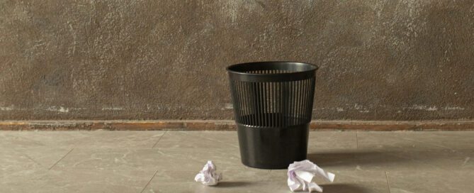 trash can with crumpled bank statements thrown at it