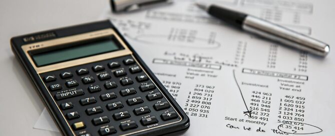 bookkeeping tools, pen, calculator, and balance forms