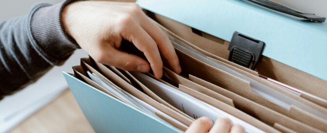 hands searching through a file folder - time to get your taxes organized