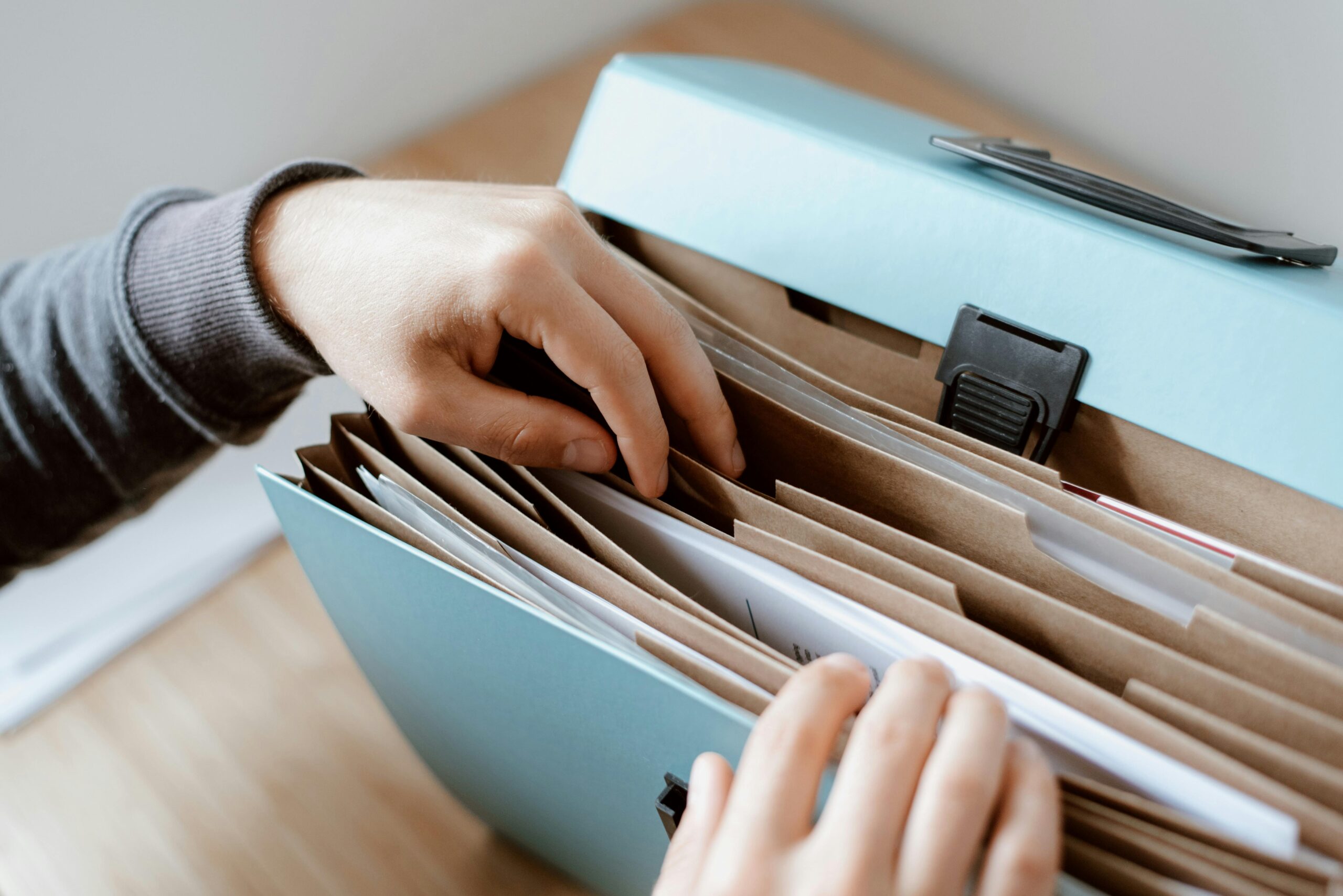hands searching through a file folder - time to get your taxes organized